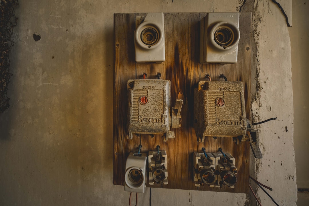 A couple of electrical boxes sitting on top of a wall