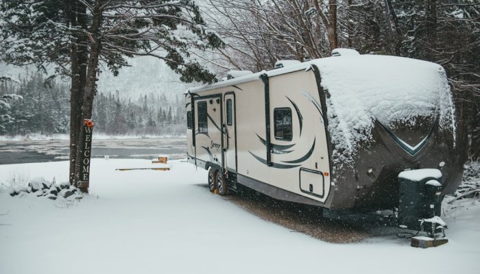 white and brown camper trailer on snow covered ground